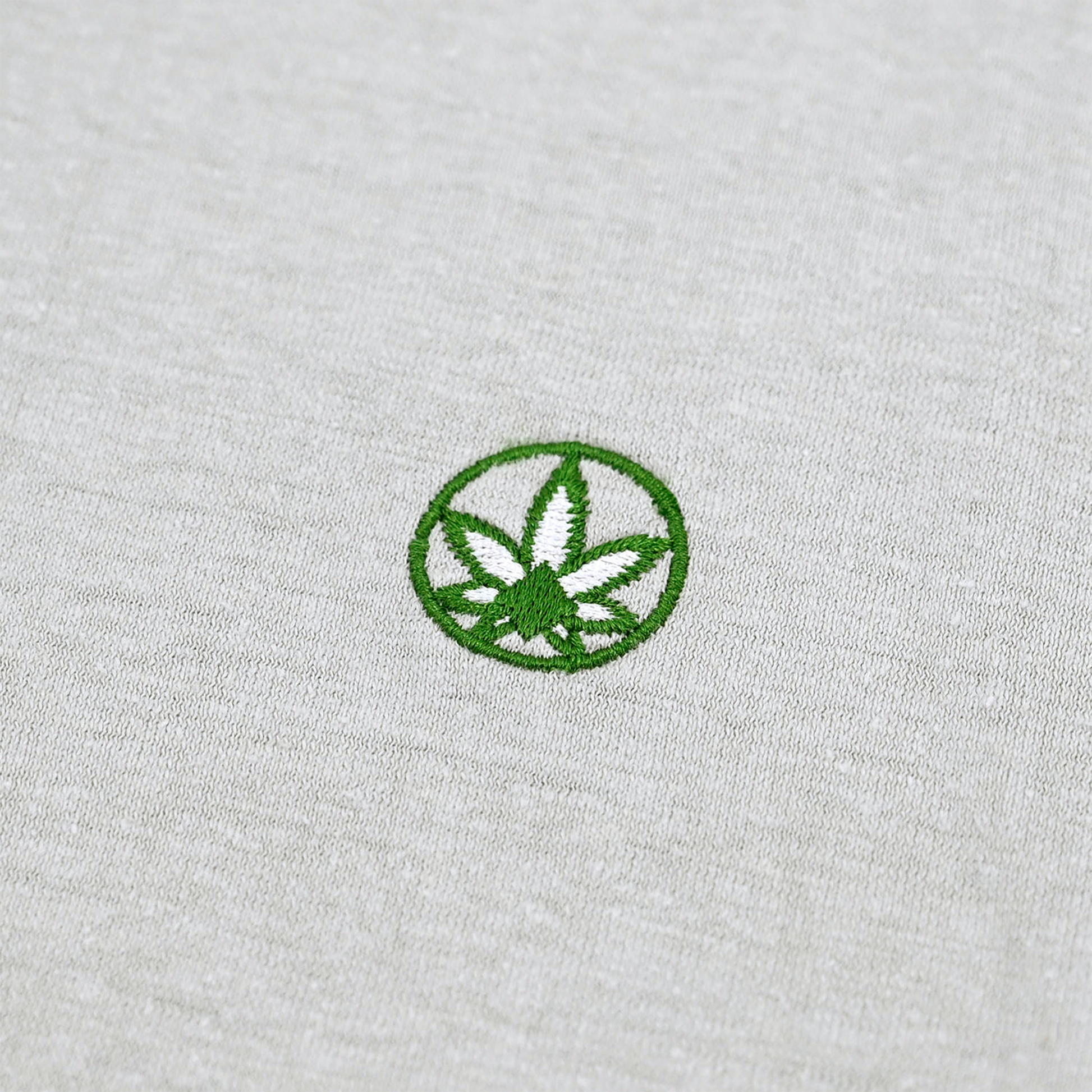 A close up photo of the Amend Co. embroidered logo on gray organic cotton and organic hemp sustainable fabric