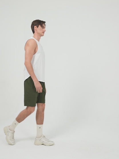 Amend Co. Male Model Wearing Sustainable White Tank Top and Green Shorts